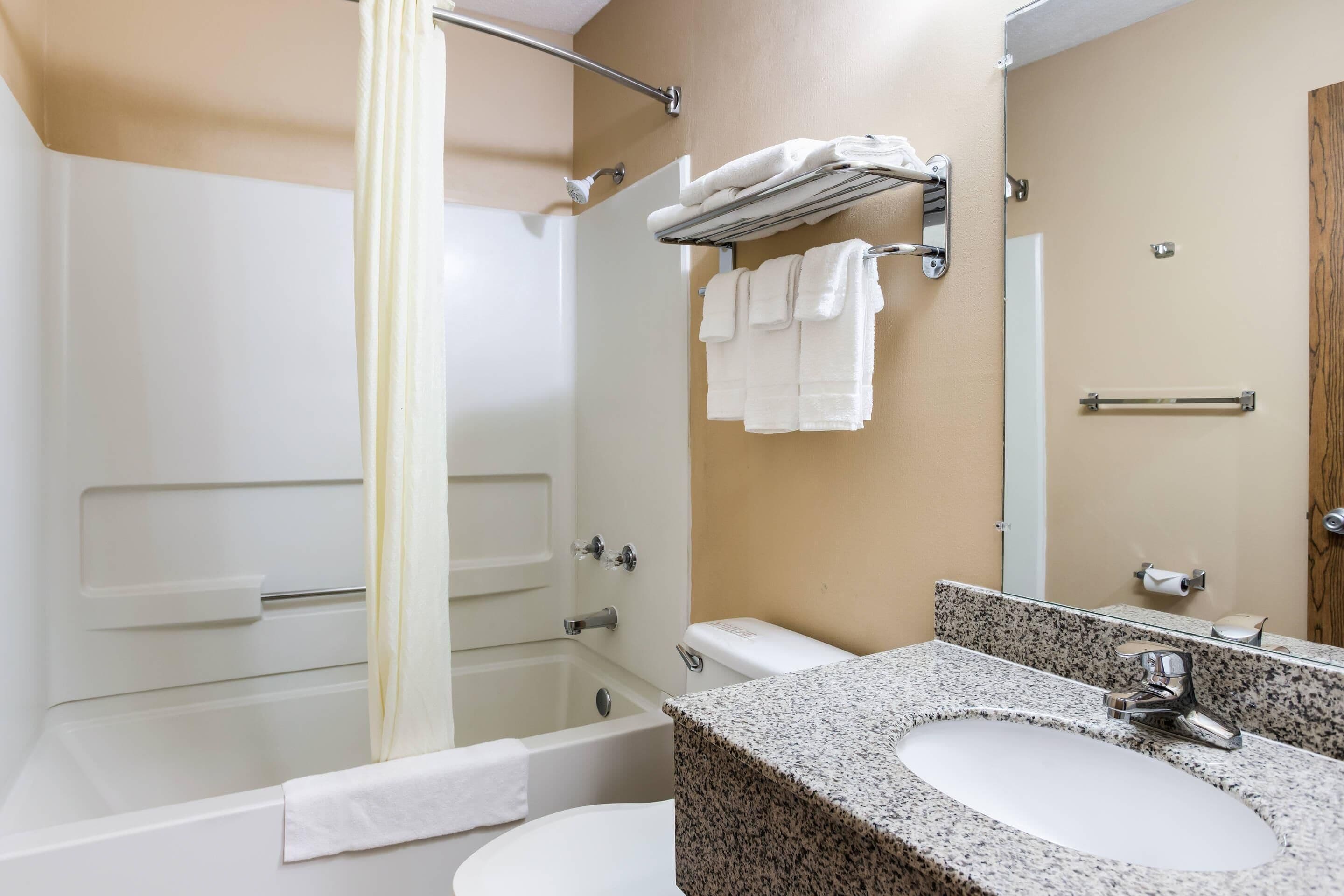 Un baño con bañera, lavamanos y espejo.