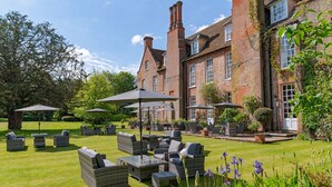 A traditional brick building with a well-maintained garden and outdoor seating area. - Hintlesham Hall Hotel (Ipswich)