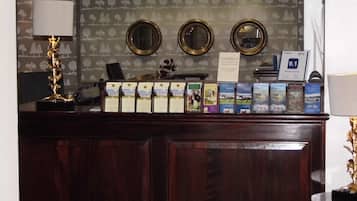 A reception desk with a wooden panel, two round mirrors, a lamp, and informational brochures.