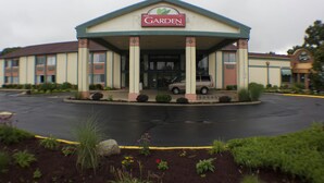 A hotel with a prominent 'Garden Inn' sign, a covered entrance, and a parking lot.