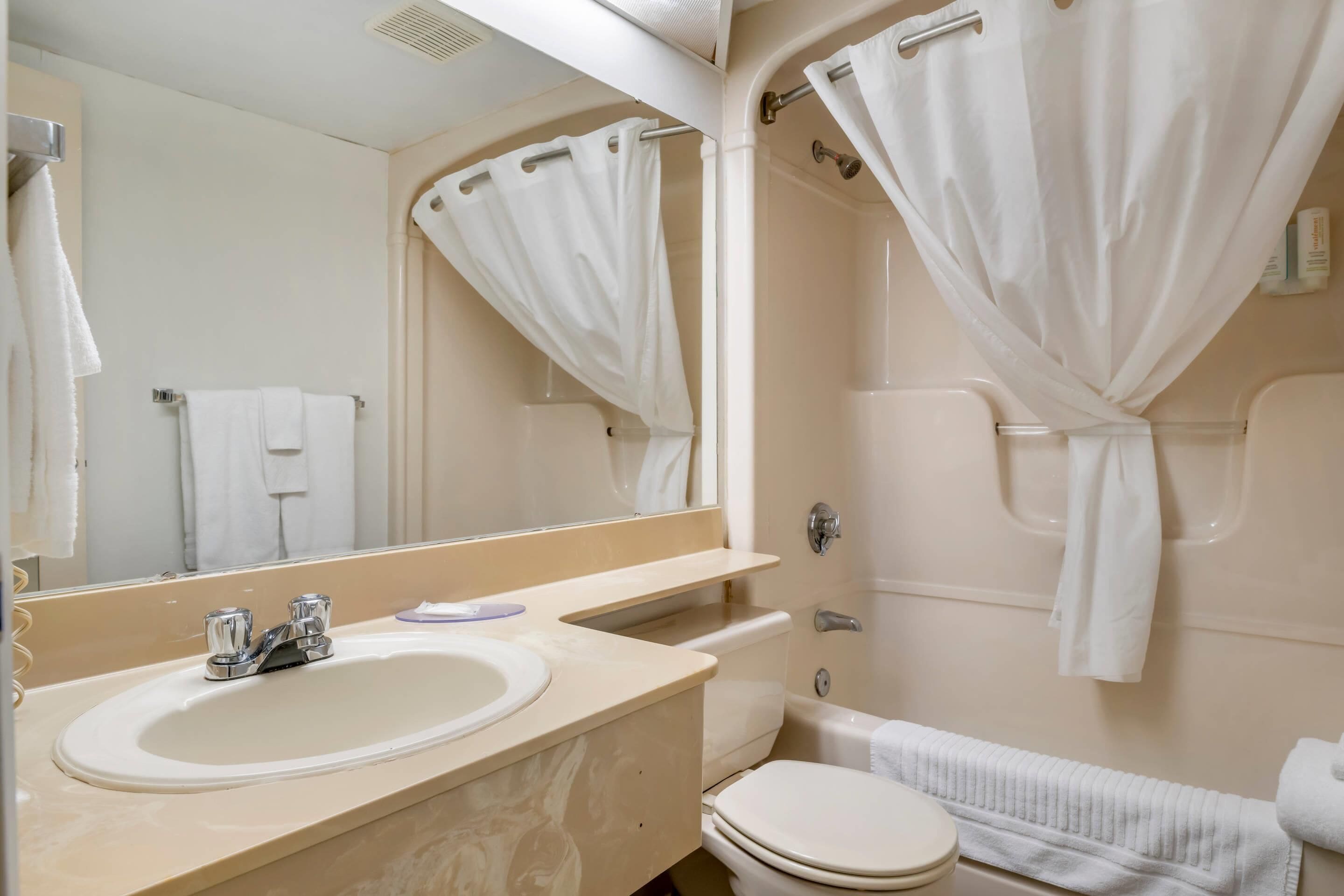 A bathroom with a sink, toilet, and bathtub.
