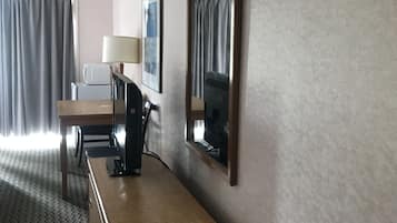 Escritorio, cortinas blackout y tabla de planchar con plancha