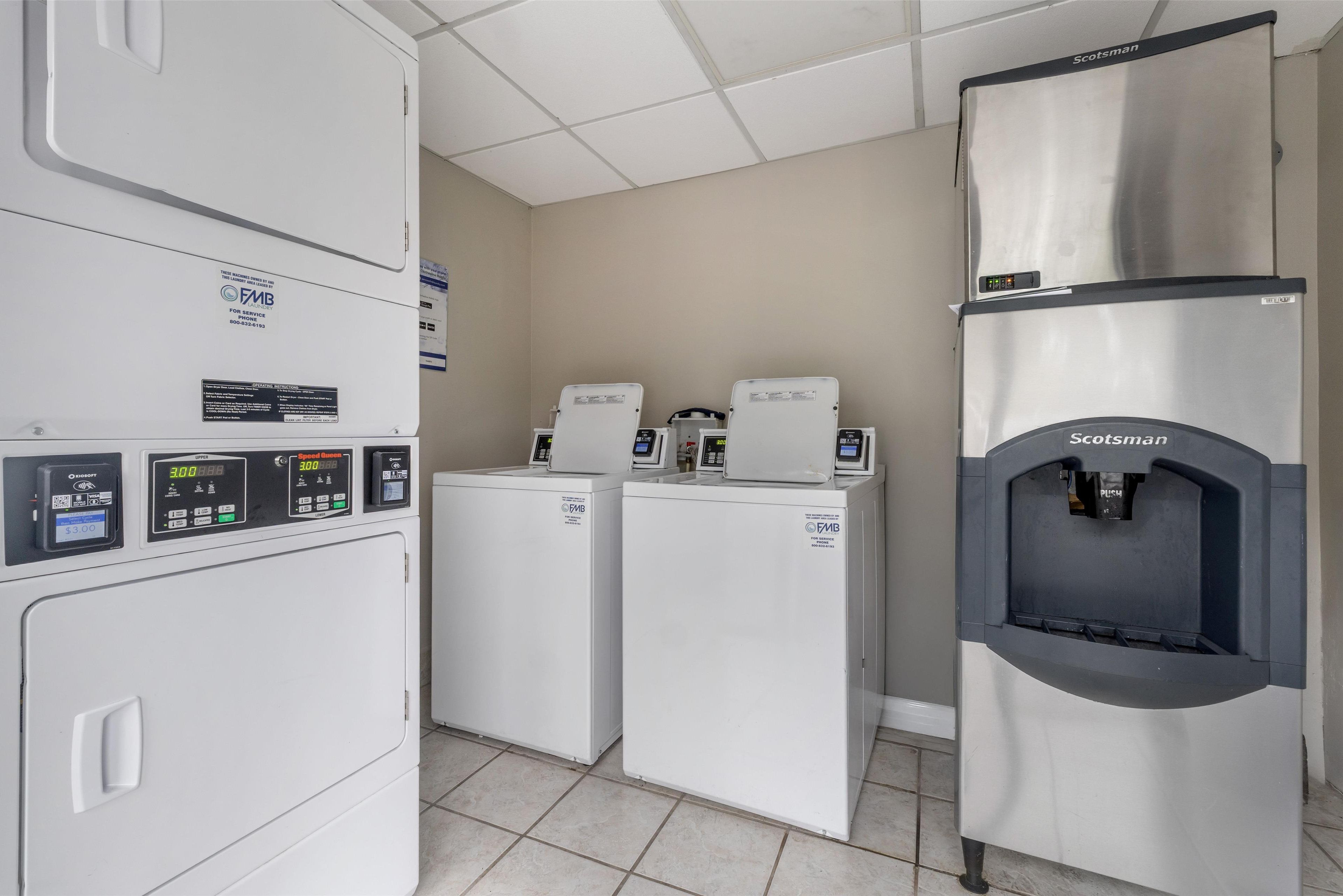 A laundry facility with multiple washing machines and a water dispenser.