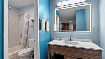 A bathroom with a bathtub, toilet, and sink.