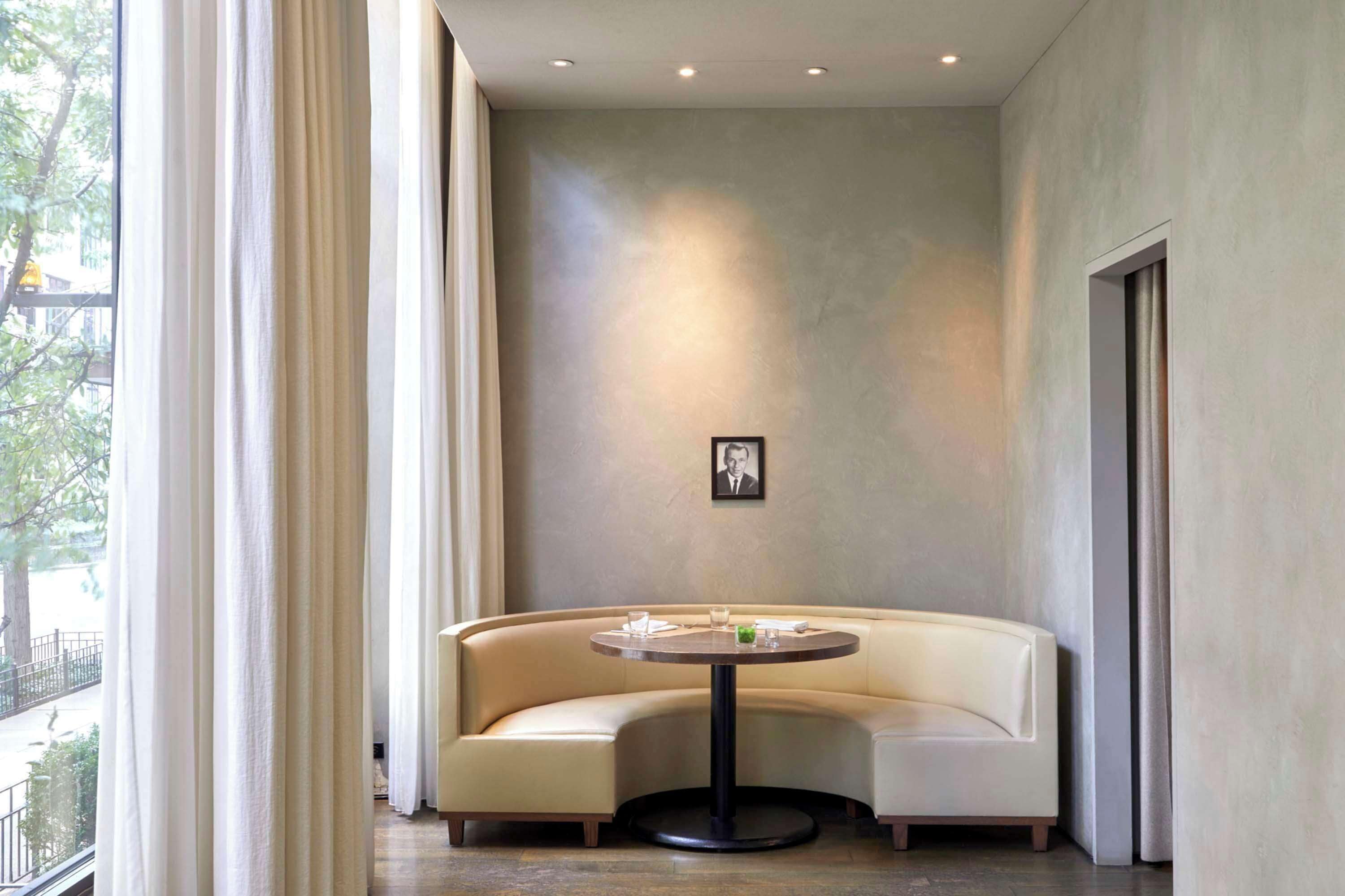 A modern room with a curved sofa, a round table, and a framed picture on the wall.