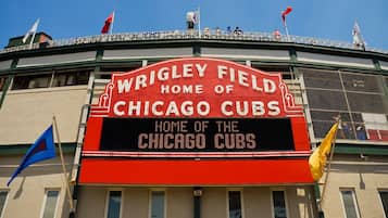 Un stade sur lequel est apposée une grande enseigne indiquant : « Wrigley Field, le stade des Chicago Cubs ».