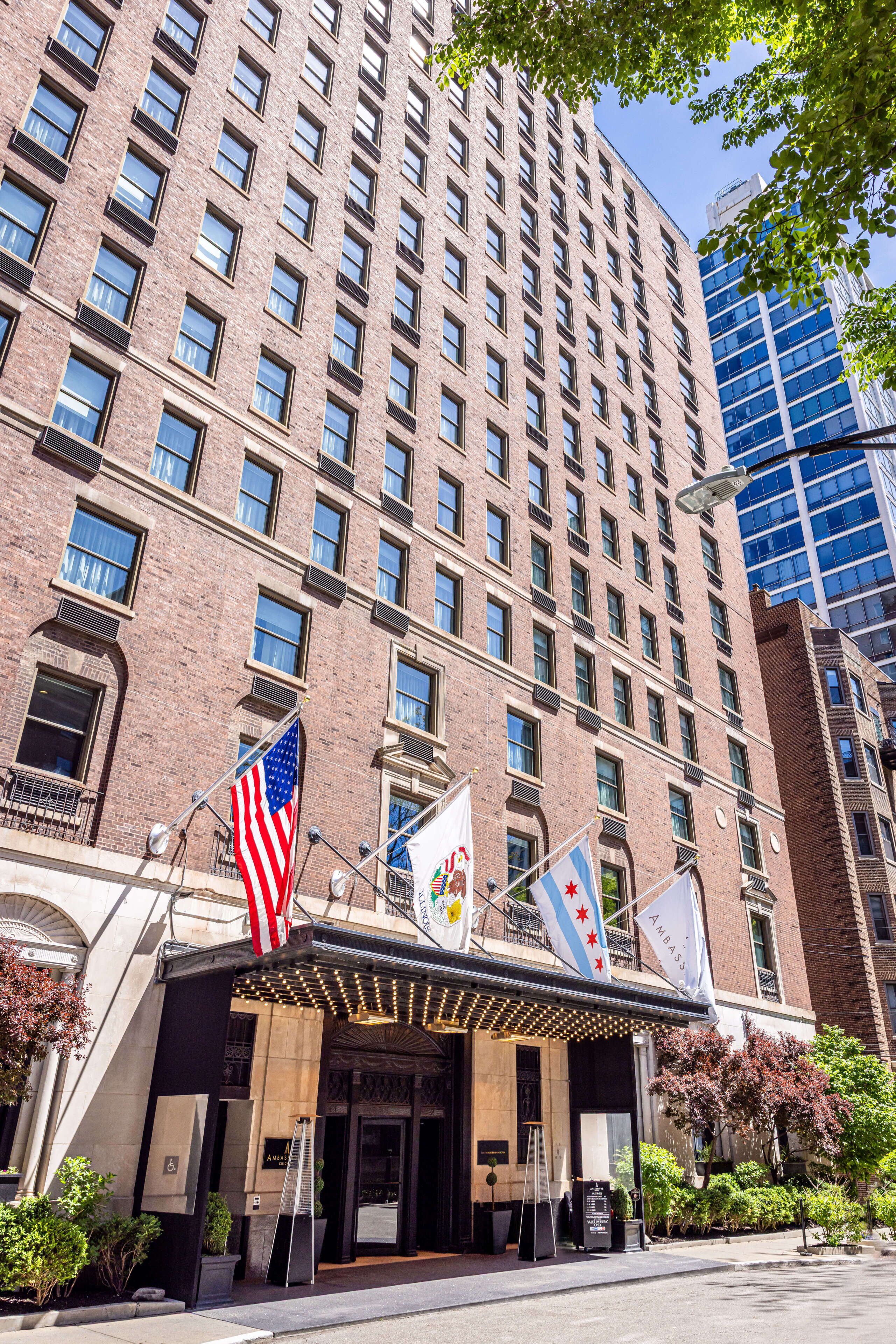 A multi-story hotel with a brick facade, multiple windows, and flags.