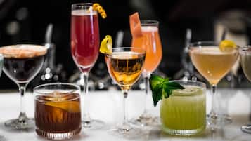 A variety of cocktails in different glassware on a marble surface.