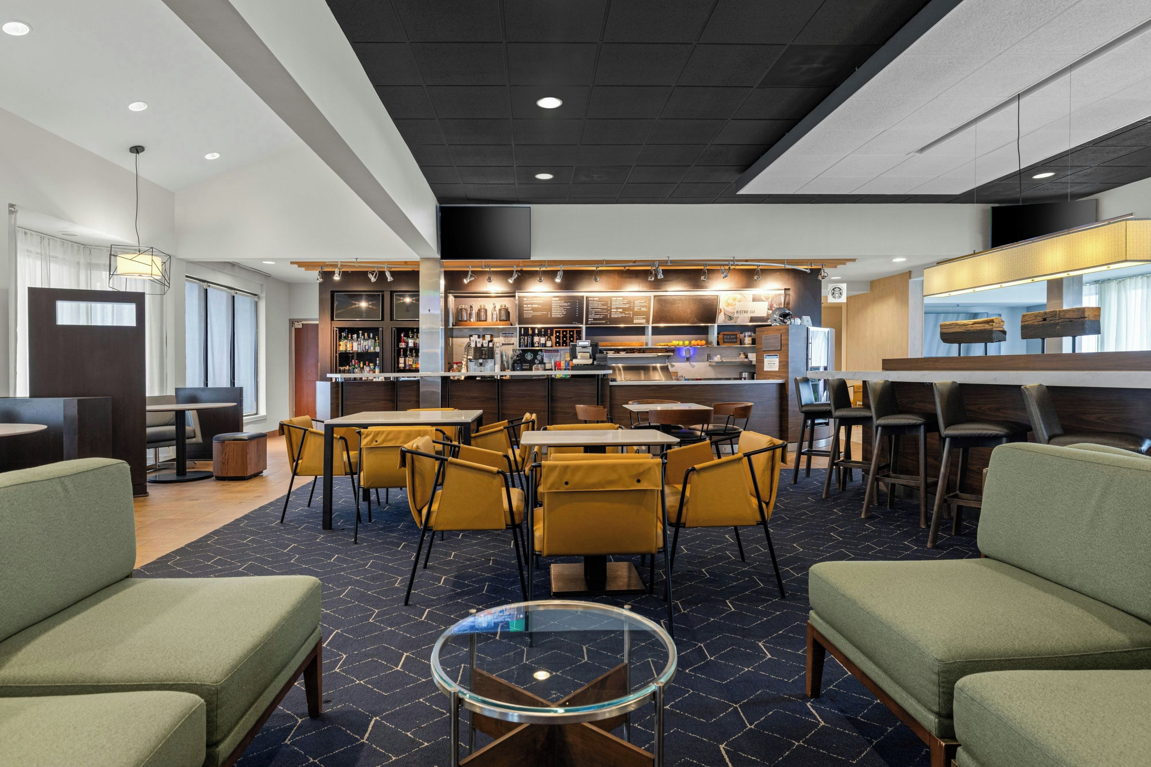 Un área de bar moderna con asientos y una estación de café.