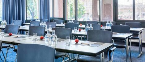 A conference room with tables, chairs, and water bottles.