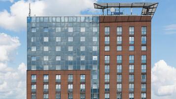 A modern building with a glass facade and a brown brick base.