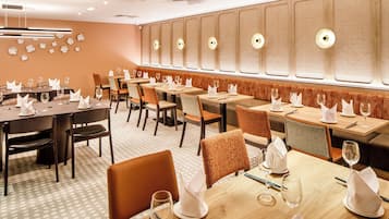 Een restaurant met verschillende tafels, stoelen en een vloer met een patroon.