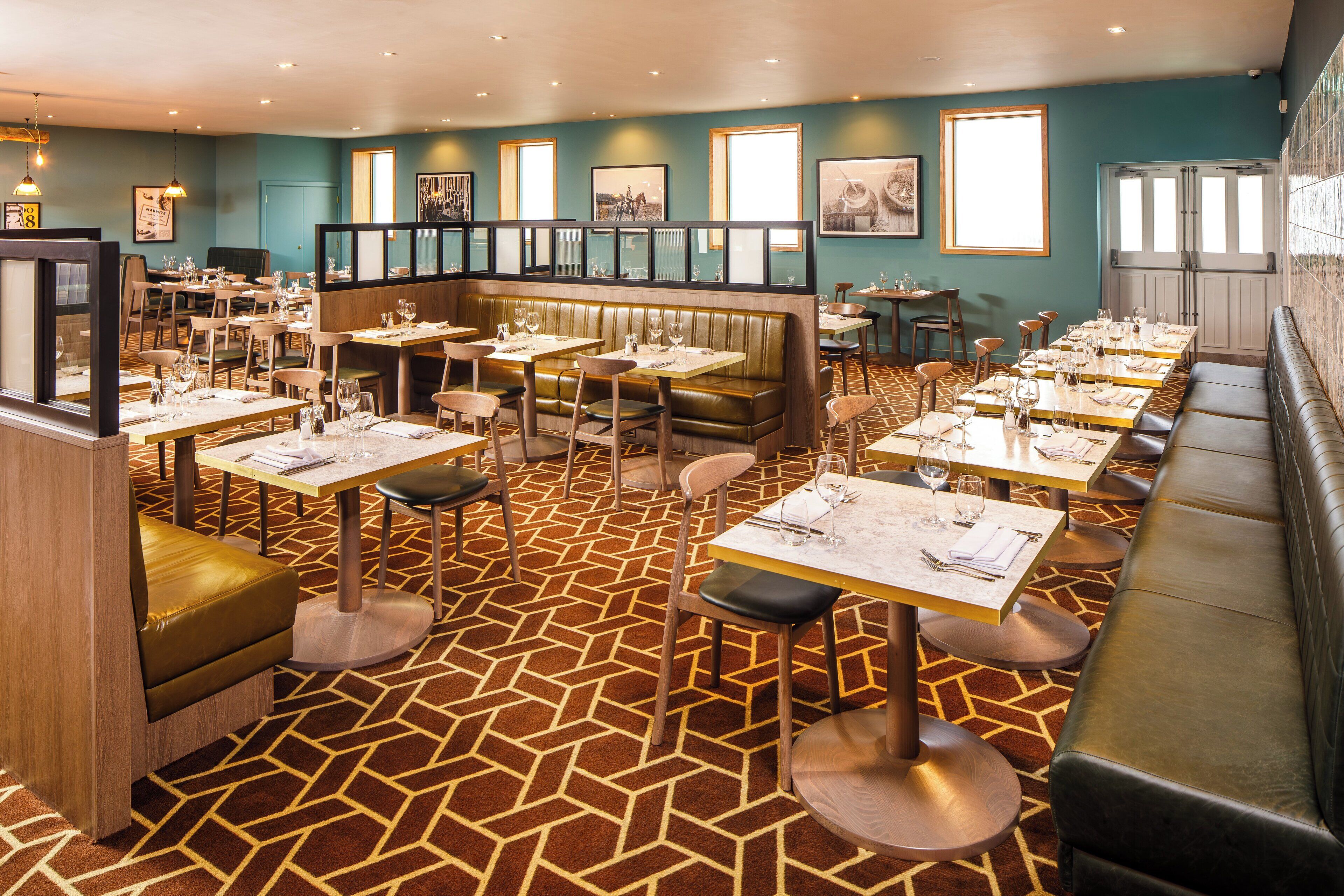 A restaurant with booths, tables, and a patterned floor.
