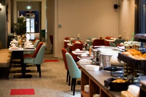 Un restaurante con varias mesas y sillas, algunas con centros de mesa florales.