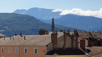 A building with a bell tower, surrounded by mountains and a clear sky.
