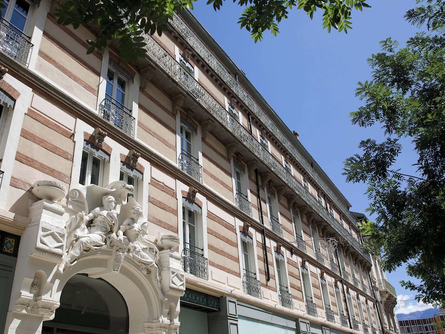 A historic building with ornate balconies and classical architectural details.