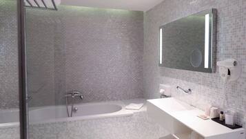 A modern bathroom with a glass shower enclosure, a freestanding bathtub, and a white vanity with a large mirror.