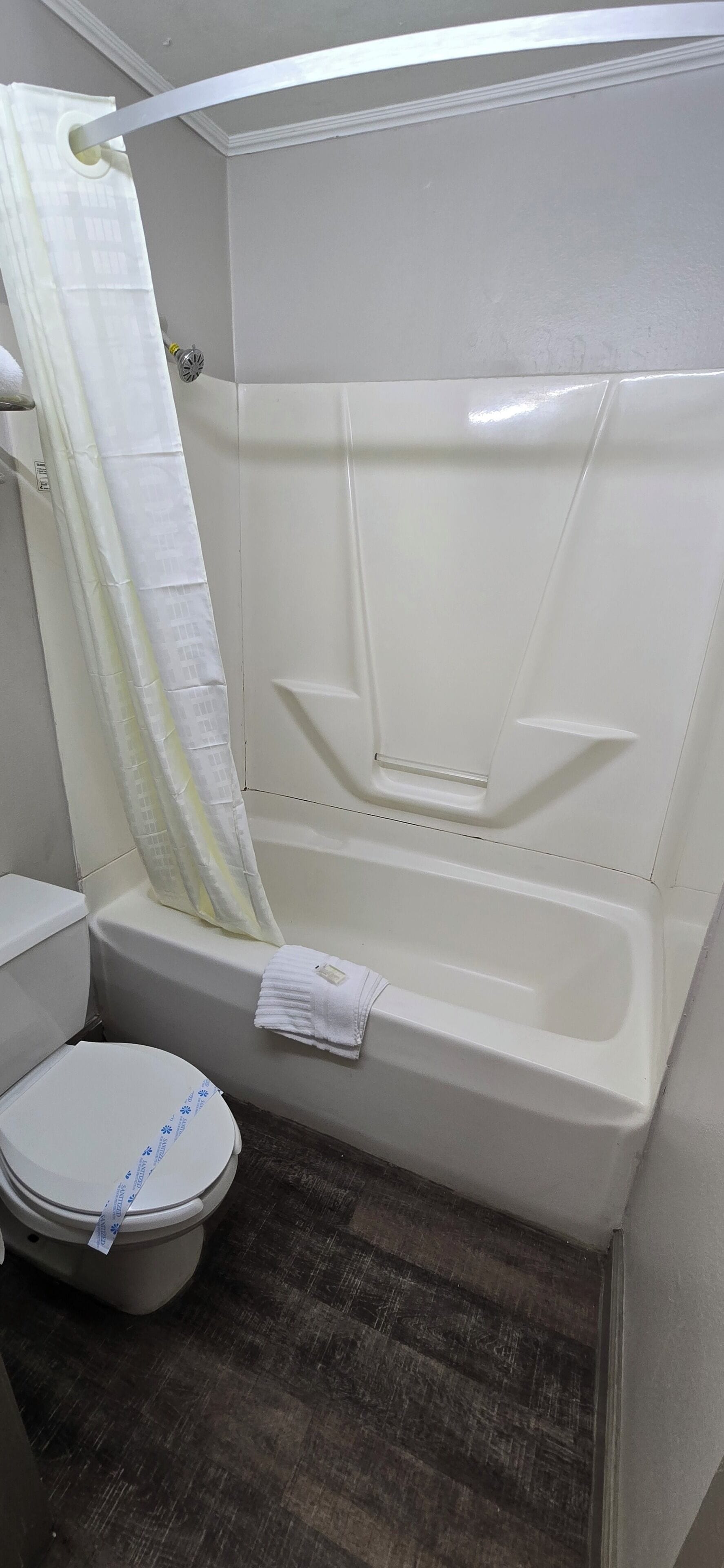 A bathroom with a bathtub, toilet, and shower curtain.