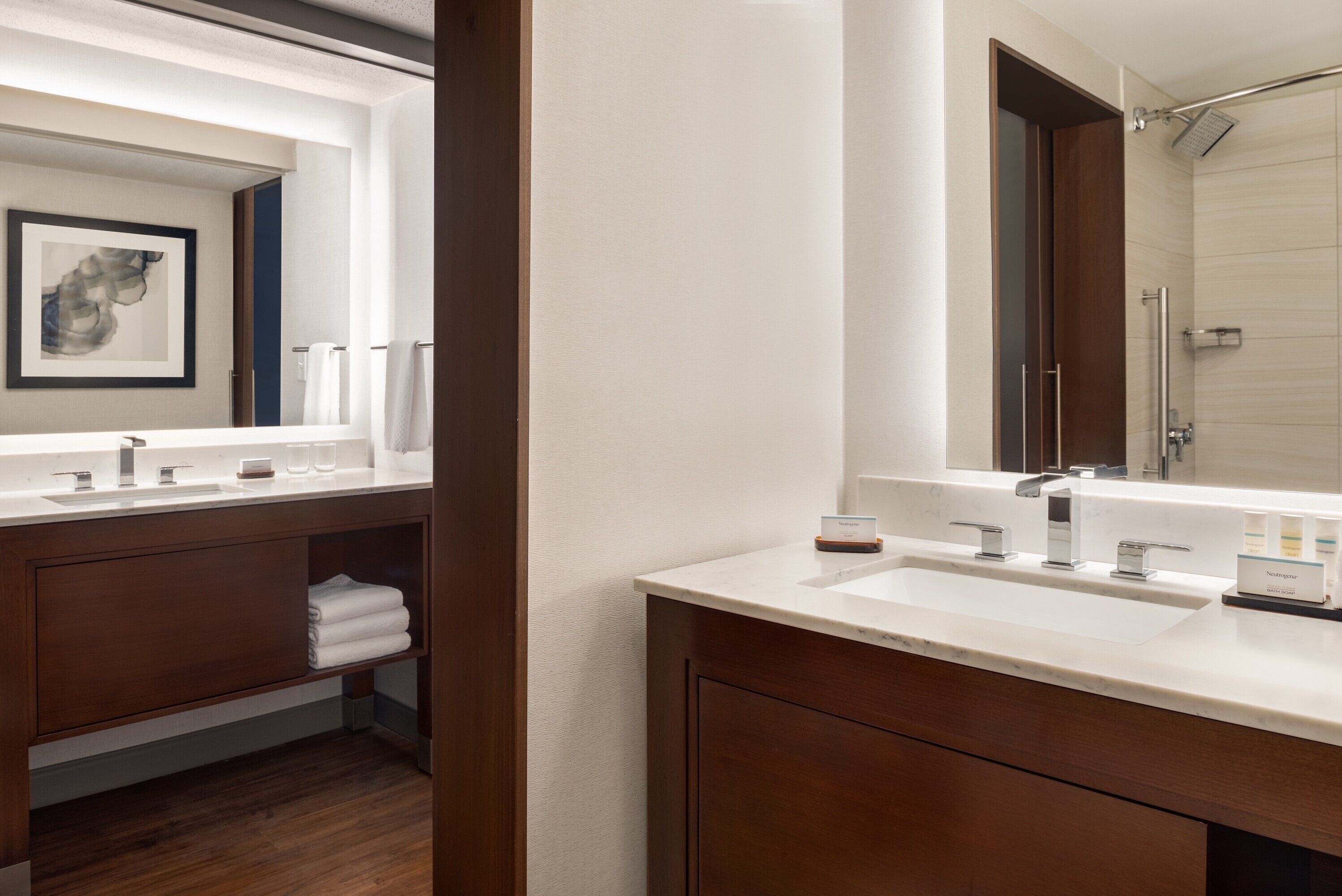 Un bagno moderno con uno specchio grande, due lavabi e una doccia.