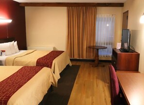 A hotel room with two beds, a small table, a TV, and a window with curtains. - Townhouse Hotel Grand Forks (Grand Forks)