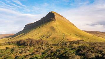 A mountain with a distinct peak and a valley below.
