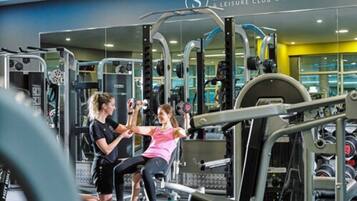A gym with various exercise equipment, a mirror, and a sign for the Sligo Park Hotel.