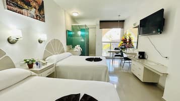 Une chambre d’hôtel avec deux lits, un bureau, une télévision et une salle de bain.
