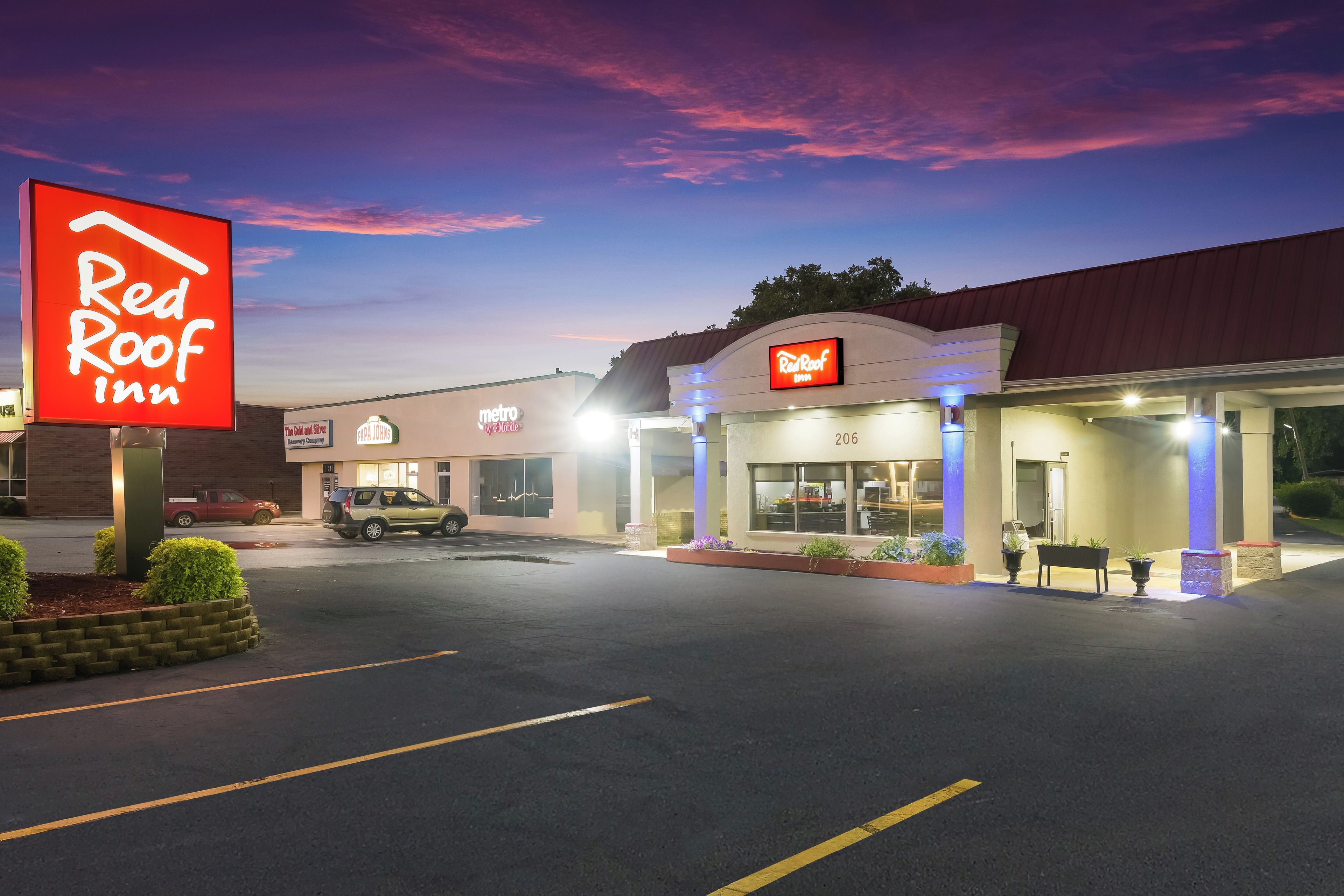 A Red Roof Inn with a clear sky and a sunset.