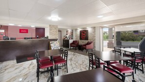 A restaurant with a marble floor, red upholstered chairs, and a counter with a 'Free Wi-Fi' sign. - Red Roof Inn Lenoir (Lenoir)