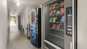 A hallway with vending machines, including a Pepsi cooler and a machine with snacks and drinks. - Red Roof Inn Lenoir (Lenoir)