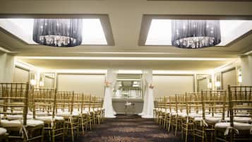 A hotel room with a view of the sky through skylights, a carpeted floor, and a mirror on one wall.