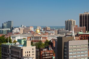 A cityscape with a prominent building featuring a golden dome, surrounded by various other buildings.