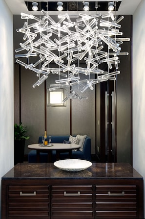 A modern dining area with a dark wood cabinet, a round table, and a blue sofa. - Hyatt Regency Boston (Boston)