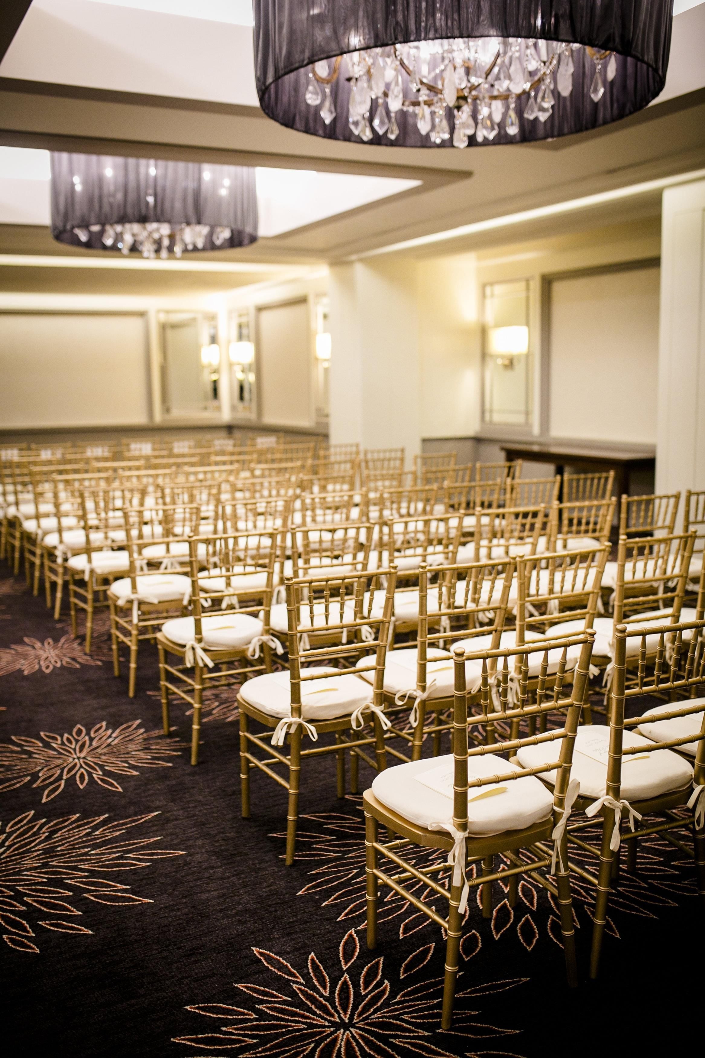 A conference room with rows of chairs and a carpet with a leaf pattern.