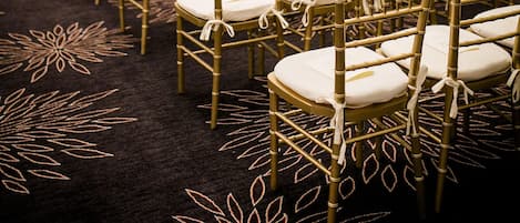 A conference room with rows of chairs and a carpet with a leaf pattern.