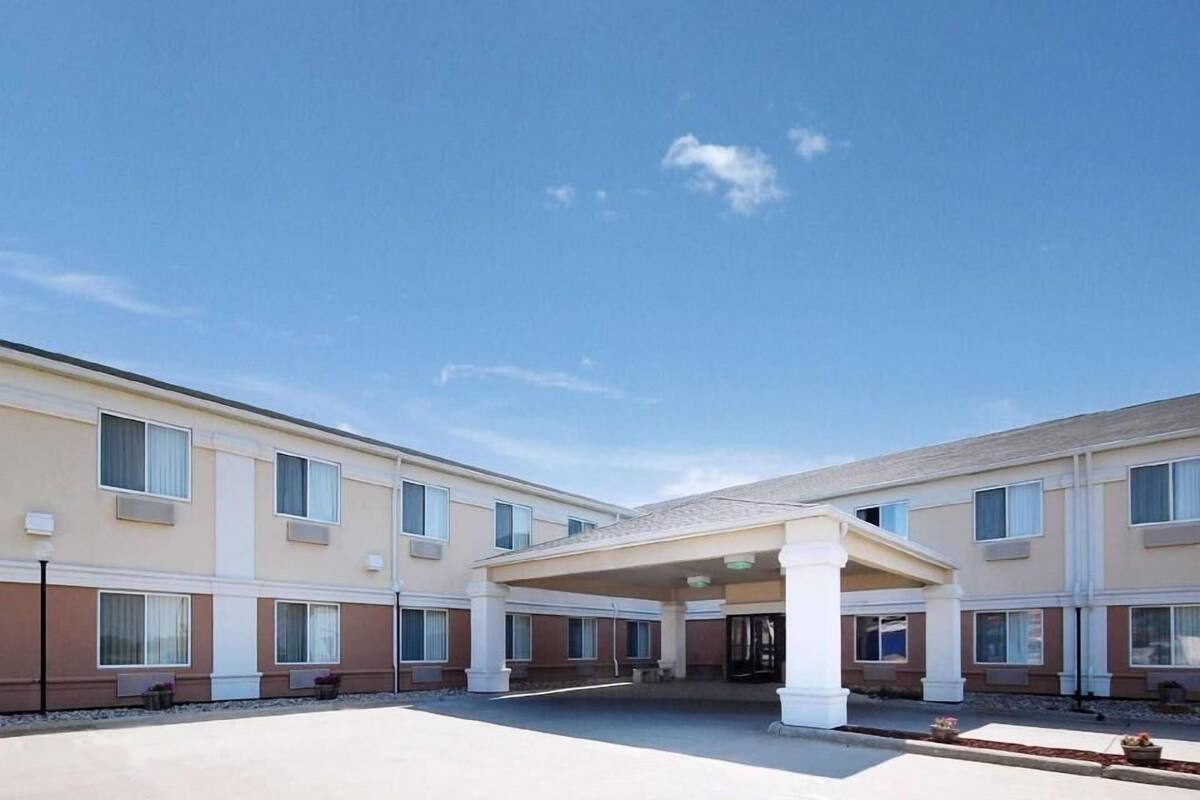 A multi-story hotel with a covered entrance and a clear sky.