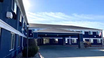 A two-story building with a covered parking area and an American flag.