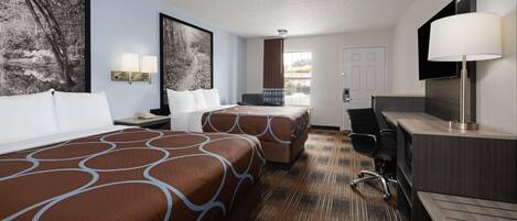 A hotel room with two beds, a desk, a chair, a TV, and artwork on the walls.