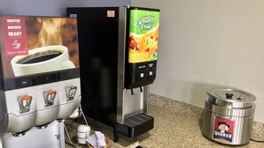 Una máquina de café y un dispensador de jugo sobre una encimera de cocina.