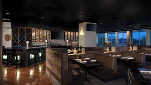 A bar area with a wine rack, seating, and a TV screen.