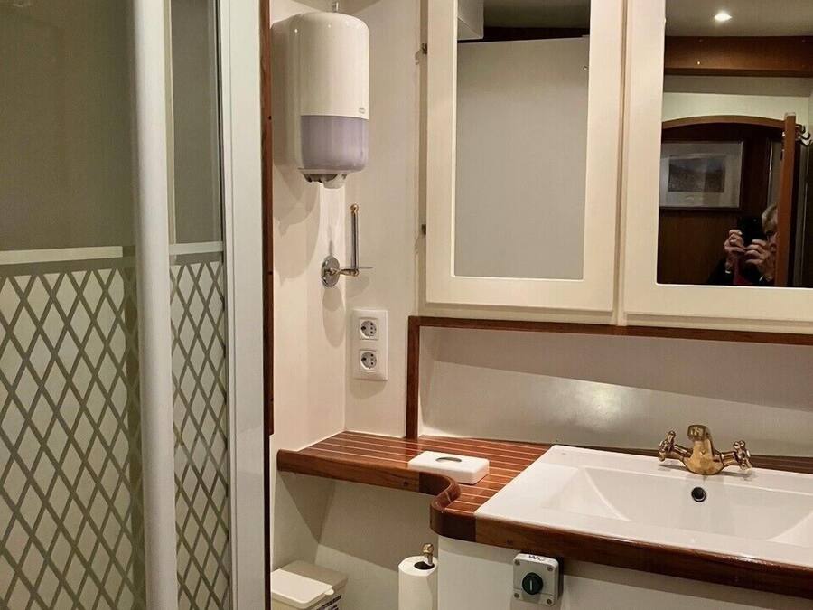 Une petite salle de bain comprenant des toilettes, un lavabo et un miroir.
