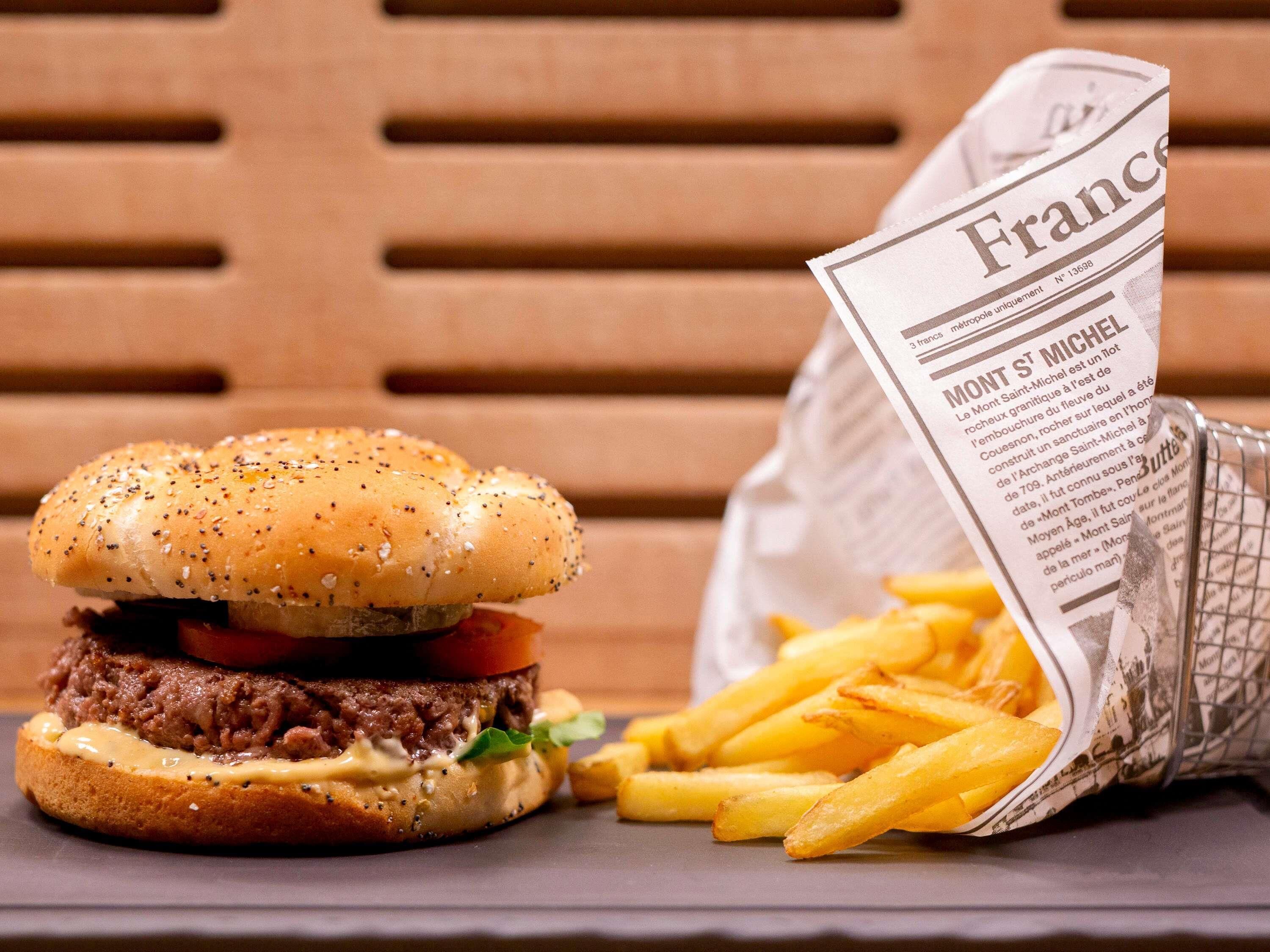 Una hamburguesa con papas fritas y un periódico.