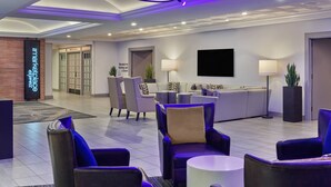 A modern lobby with seating areas, a reception desk, and a sign indicating elevators to parking and a street. - Marriott Vacation Club®, San Diego (San Diego)