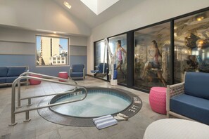 A modern indoor pool area with a hot tub, seating, and a view of city buildings. - Marriott Vacation Club®, San Diego (San Diego)
