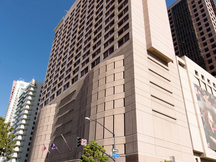 Un edificio alto y moderno con fachada plana y una entrada amplia.