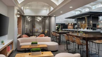 A spacious lounge area with a sofa, a coffee table, and a bar with stools.