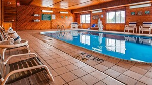 A wooden cabin with a pool area, including lounge chairs and a lifeguard stand. - Quality Inn Tomah (Tomah)