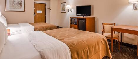 Une chambre d’hôtel avec deux lits, un bureau, une chaise, une télévision et un réfrigérateur.