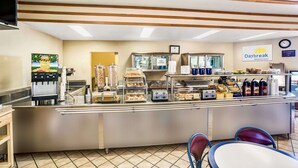 A breakfast area with a counter, coffee machine, and seating. - Days Inn & Suites by Wyndham Fullerton (Fullerton)
