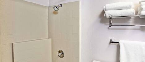 Un baño con bañera, ducha, inodoro y toallero.